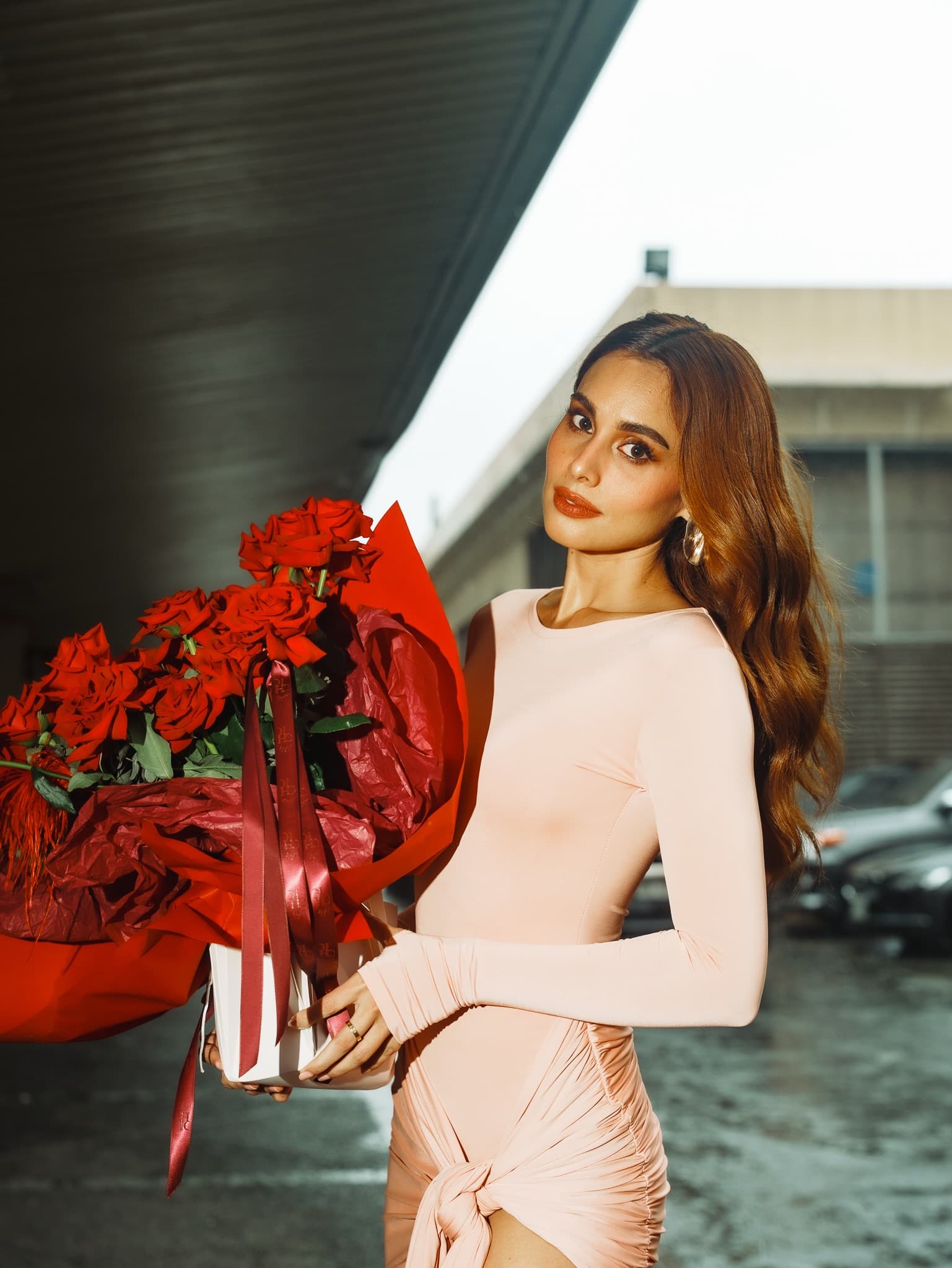 Max Collins holding a bouquet of red roses by Holy Chic Flowers at It’s Showtime Studio