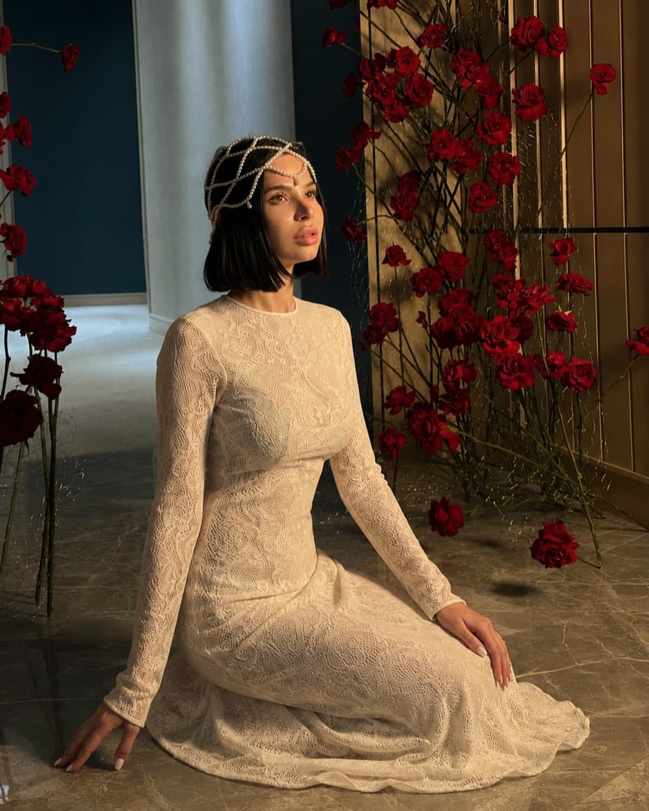 Inessa Bertta, Co-founder and Lead Florist of Holy Chic Flowers, surrounded by a red rose installation