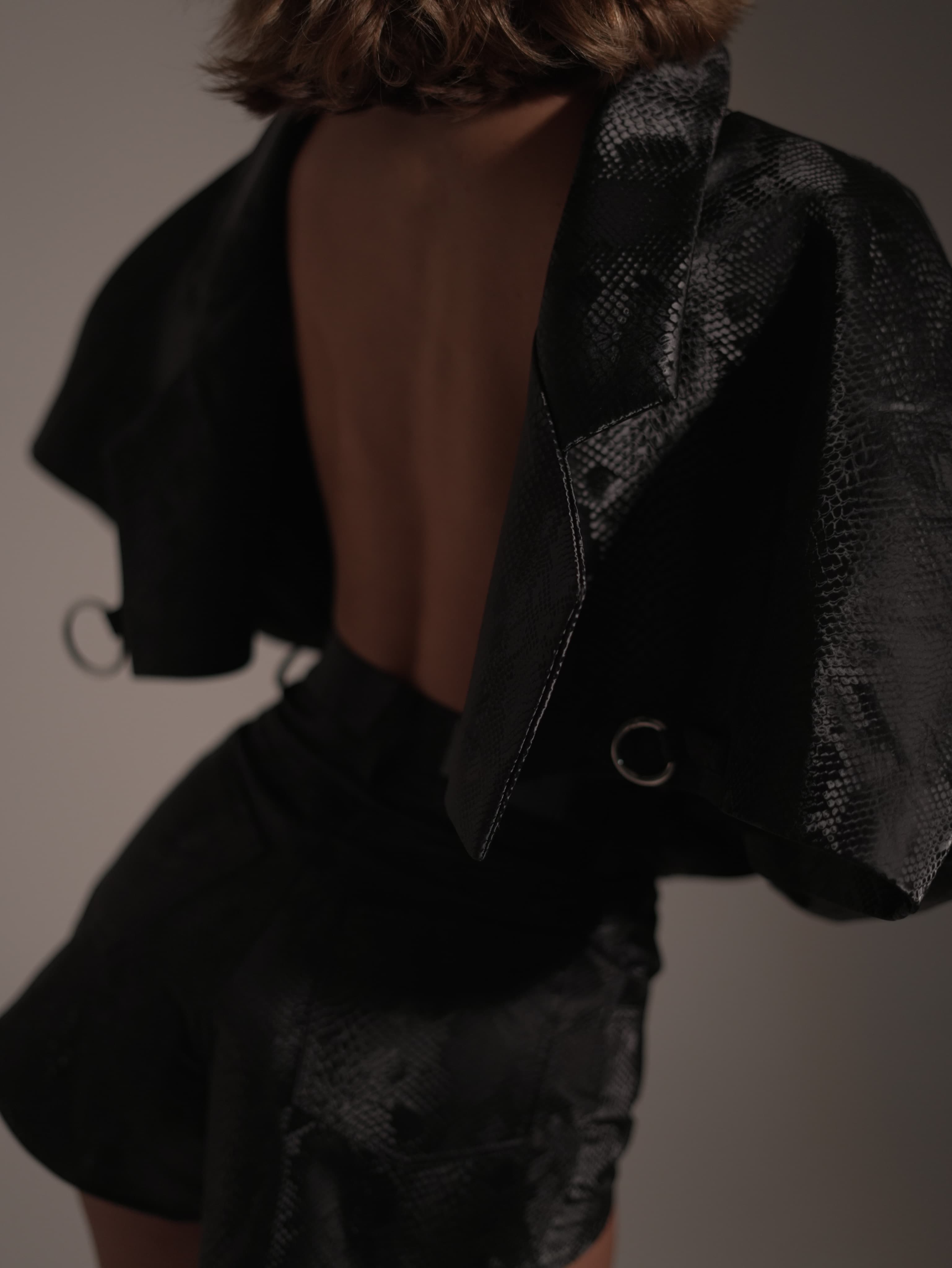 Fashion detail of Masha in a textured black Lyssai Limited look
