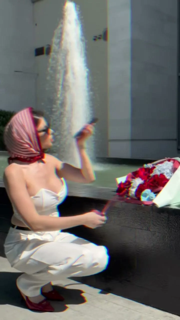 Woman revealing a red and white Holy Chic rose bouquet beside a car