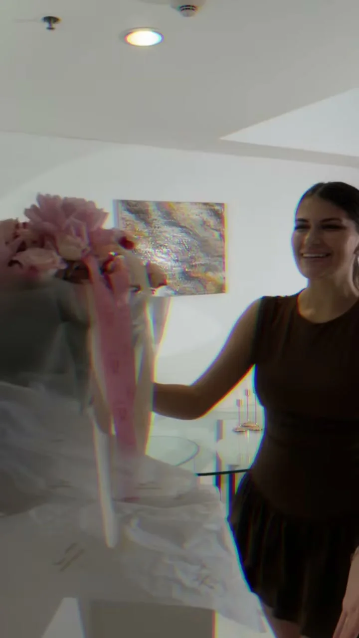 Woman revealing an oversized pink Holy Chic bouquet indoors