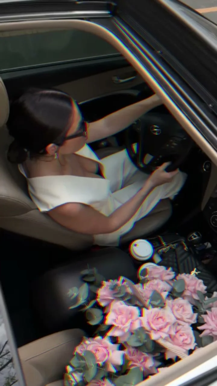 Woman in a car with a pink Holy Chic rose bouquet