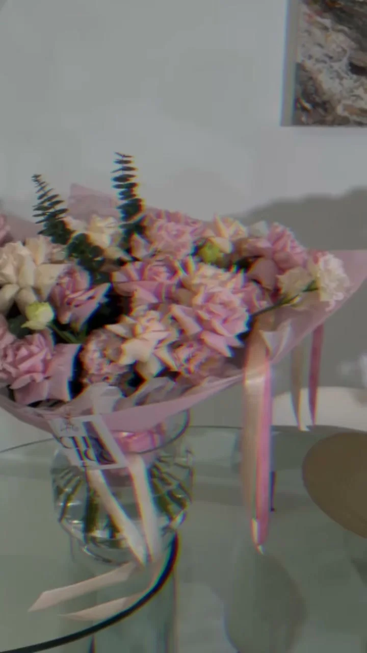 Pink garden-style Holy Chic bouquet displayed on a glass table