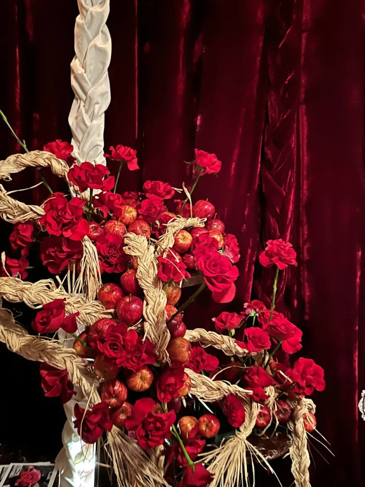 Apple and red rose installation detail Close detail of red roses fresh apples and braided fibre in the Holy Chic installation