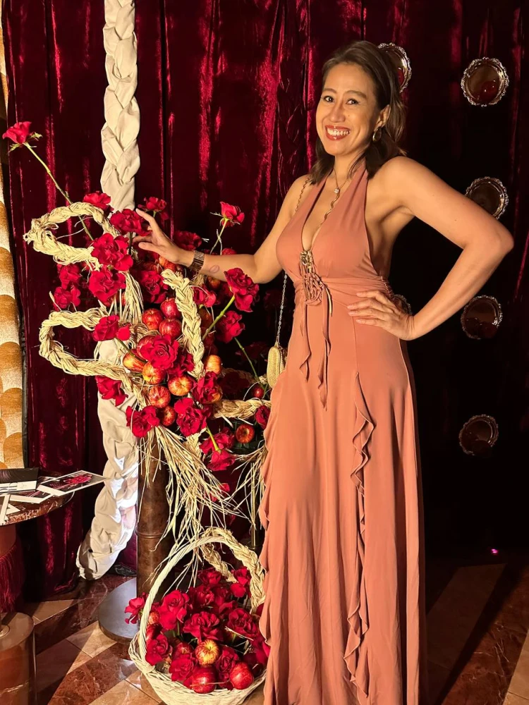 Guest portrait beside the Holy Chic installation Guest standing beside the Holy Chic apple and red rose installation at Medusa BGC